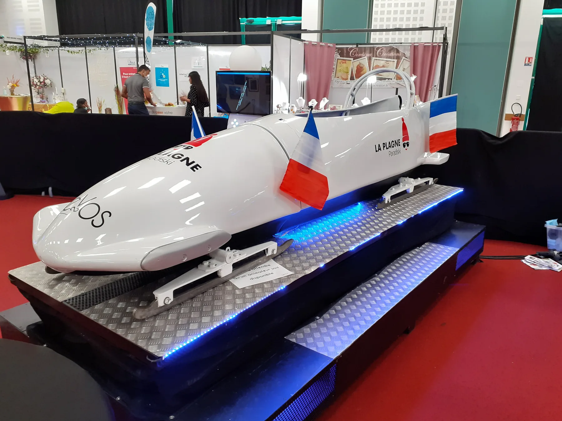 Simulateur d’avion blanc présenté sur un stand avec écran de contrôle
